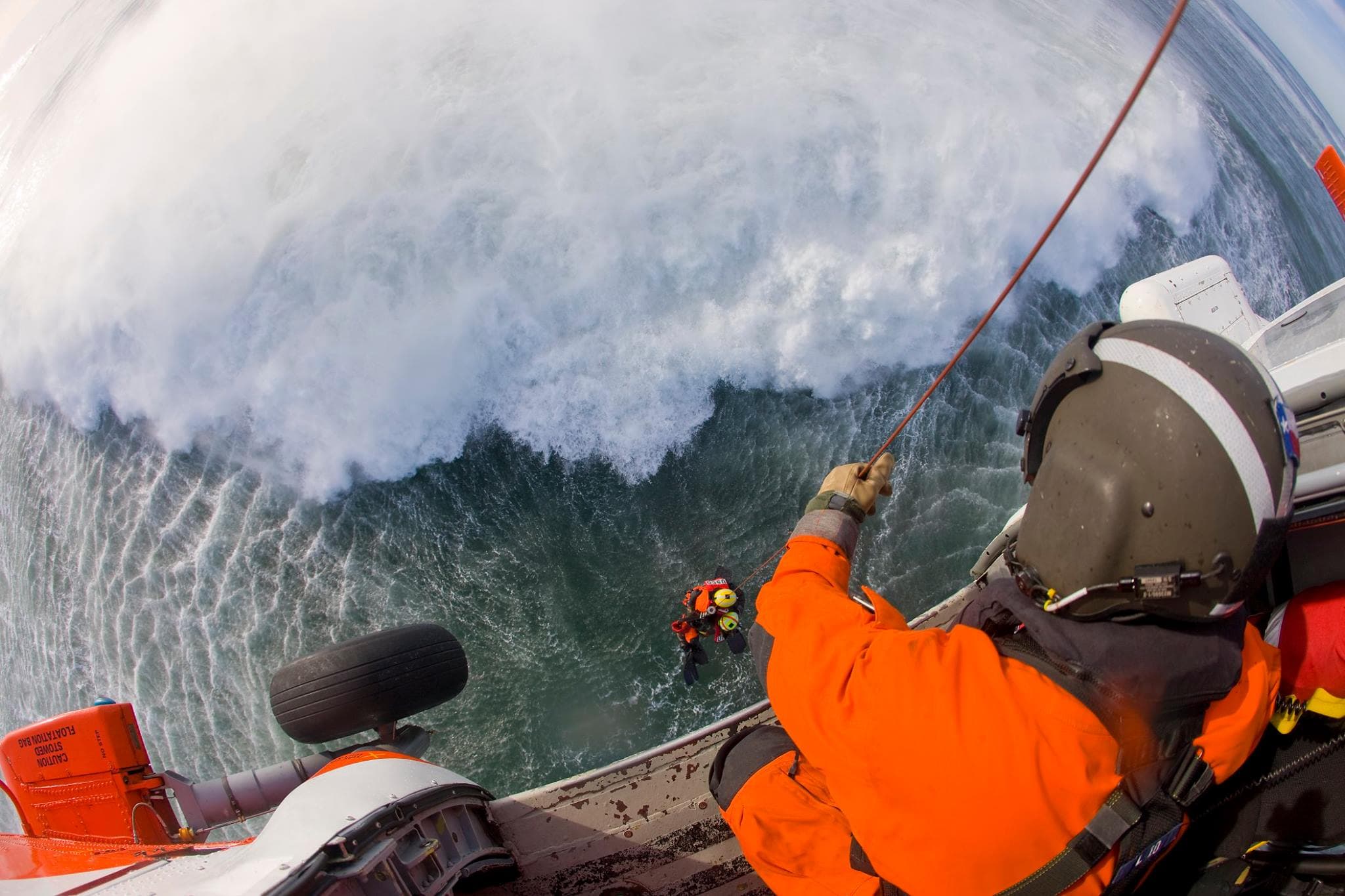 Hoist operator conducting high-sea rescue swimmer extraction