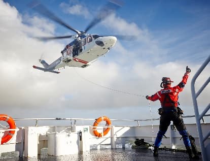 Vessel hoist operations with crew directing helicopter
