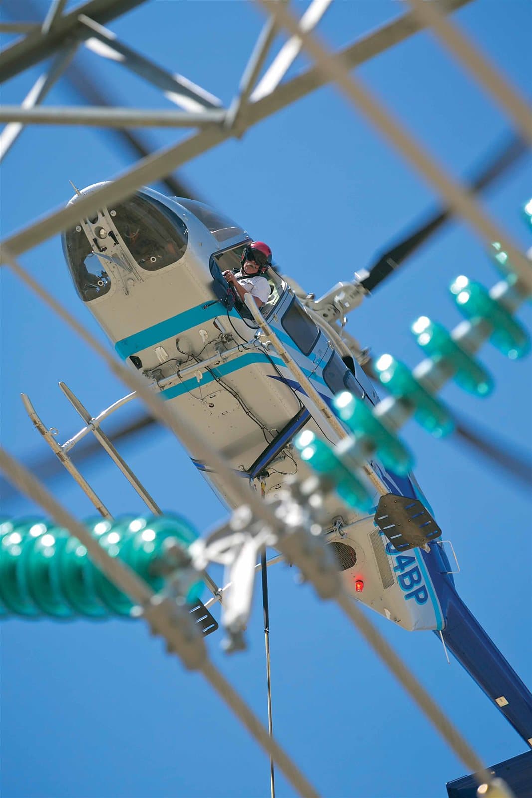 Helicopter aircrew conducting power transmission line work among the towers